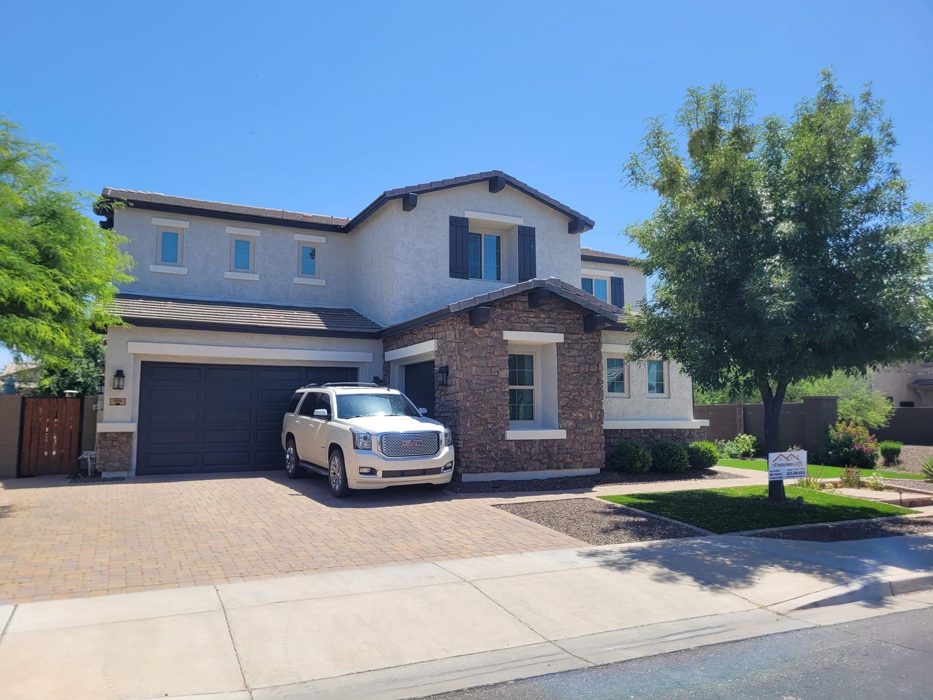 Two-story stucco and stone home freshly painted by Mr Painting Houses